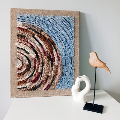 Ręcznie wykonany obraz techniką punch needle w odcieniach brązu i niebieskiego . Dekoracja ścienna o abstrakcyjnym wzorze, idealna do nowoczesnych i przytulnych wnętrz.
