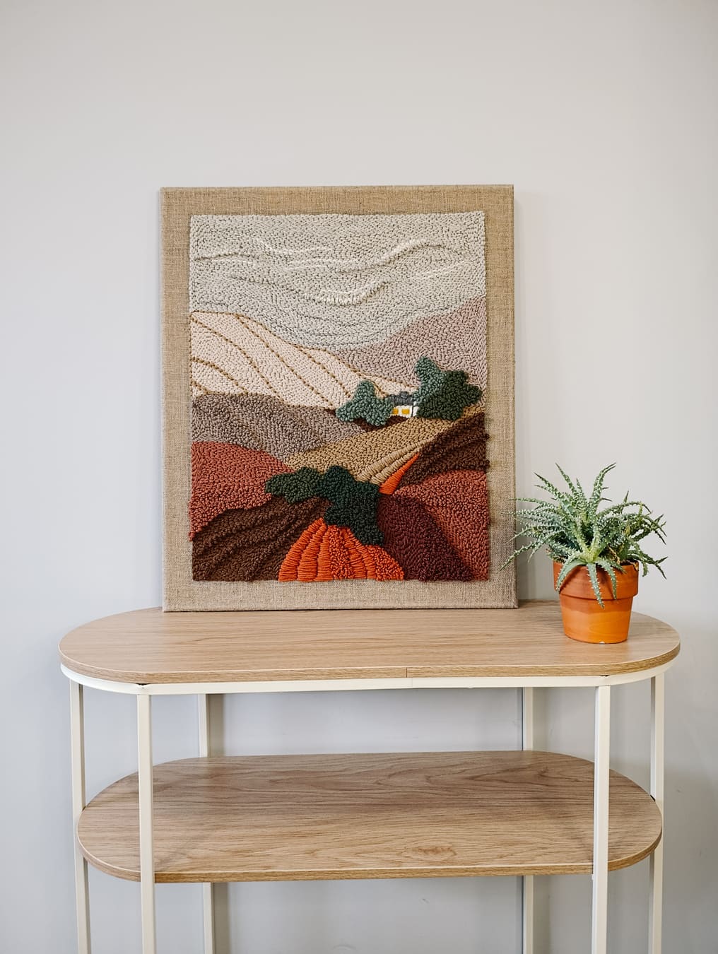 Obraz punch needle z jesiennym krajobrazem.