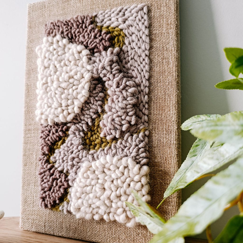 Mały obrazek punch needle z fakturą 3D w kolorach ziemi.